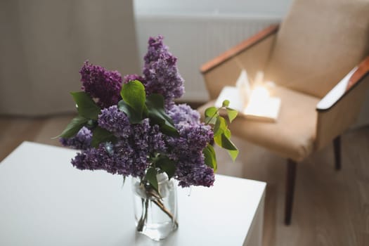 Spring branches of blooming lilac festive bouquet of flowers. Home interior decor, bouquet of lilacs in a vase on table