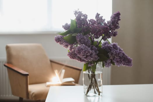 Spring branches of blooming lilac festive bouquet of flowers. Home interior decor, bouquet of lilacs in a vase on table