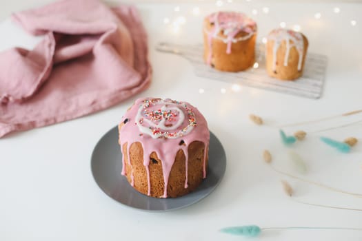 Happy Easter cake with sprinkles on glaze. Cake on light rustic board. Homemade bakery