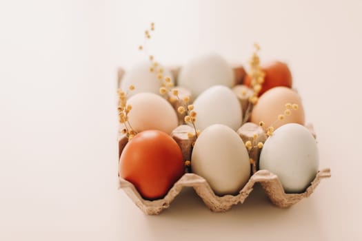 fresh chicken eggs of natural shades and colors in a recycled box on a white background. High quality photo