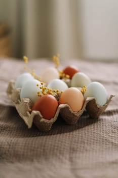 fresh chicken eggs of natural shades and colors in a recycled box on a white background. High quality photo