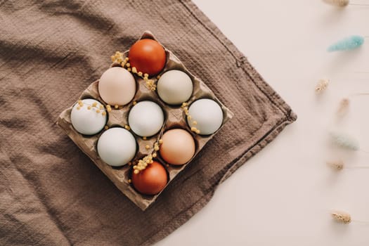 fresh chicken eggs of natural shades and colors in a recycled box on a white background. High quality photo