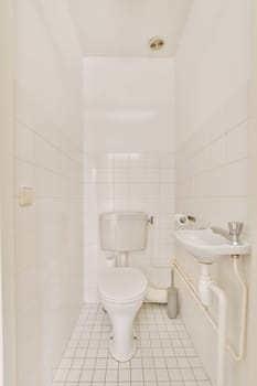 a bathroom with white tiles on the walls and floor, including a toilet in the middle part of the room