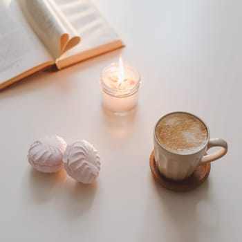 coffee cup, cotton flower, open book on a white table background top view. minimal home interior decor.