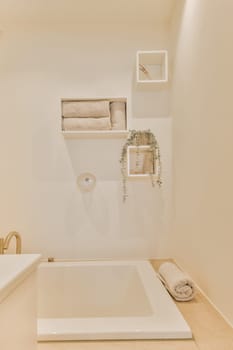 a bathroom with shelves on the wall and a white bathtub in the tub is filled with towels, soaps and other items