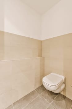 a white toilet in the corner of a bathroom with beige tiles on the floor and walls, there is no one