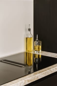a black and white kitchen counter with a bottle of olive oil on the countertop, next to it is a soap disp