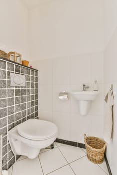 a bathroom with black and white tiles on the wall, toilet, sink, and mirror in it's corner