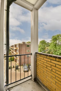 a balcony with a brick wall and blue sky in the background photo is taken from inside an apartment window stock photo