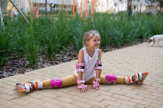 A little caucasian girl sits in a transverse twine shod in roller skates