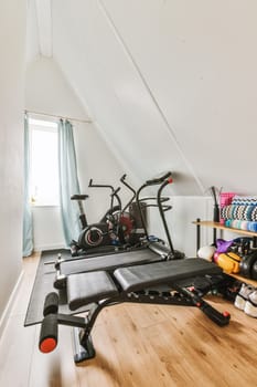 a gym room with an exercise bike and other equipment on the floor in front of the room is a window