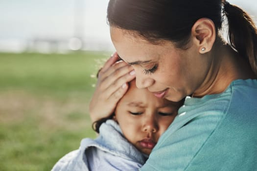 Comfort, mother and sad baby with anxiety, fear and frustrated with problems being supported and loved by mom. Family, grief and mama carrying a moody and angry girl child or kid at a park outdoors.