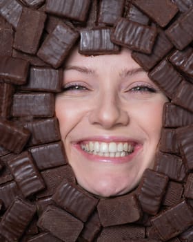 Face of caucasian woman surrounded by chocolates