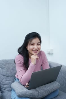 Portrait of a beautiful Asian teenage girl using a computer.