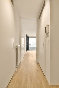 an empty room with white walls and wood flooring on either side of the room, there is a door that leads to another