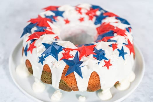 July 4th bundt cake covered with a vanilla glaze and decorated with chocolate stars on a white plate.