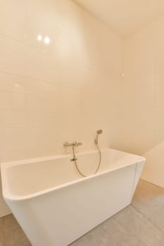 a white bathtub in the corner of a bathroom with tile flooring and walls that have been painted off