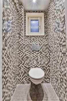 a toilet in a bathroom with tiled walls and tiles on the wall, there is an image of a window