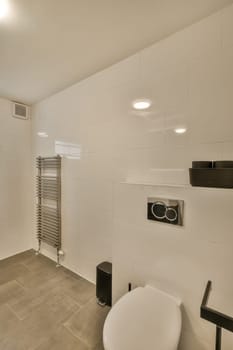 a modern bathroom with white walls and tile flooring, including a toilet in the middle part of the room