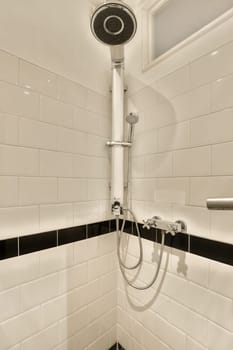 a shower with black and white tiles on the wall behind it is an open shower head that has been cleaned