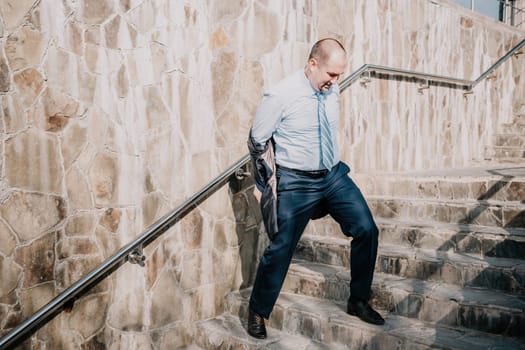 Portrait of a senior professional man in a suit with various problems. A middle-aged businessman with a briefcase descends the stairs.