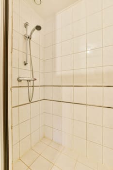 a white tiled bathroom with shower head and hand held in the shower arm to keep it from getting dirty water