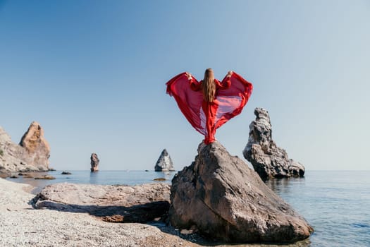 Woman travel sea. Happy tourist taking picture outdoors for memories. Woman traveler looks at the edge of the cliff on the sea bay of mountains, sharing travel adventure journey.