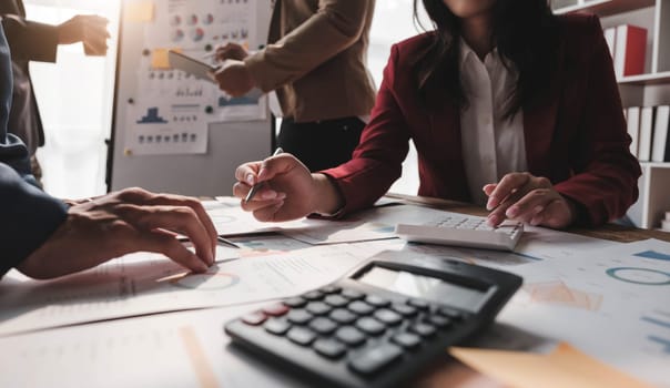 Business People Meeting using laptop computer,calculator,notebook,stock market chart paper for analysis Plans to improve quality next month. Conference Discussion Corporate Concept....