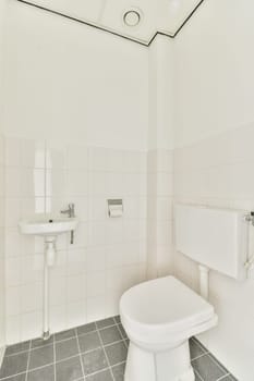 a bathroom with white tiles on the walls and floor, including a toilet in the middle part of the room