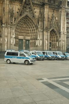 Row of Mercedes-Benz Sprinter police cars in front of Cologne Cathedral in Germany