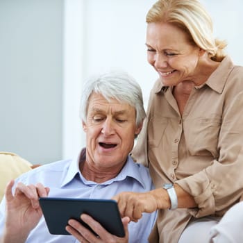 Omg, it did not just do that...a happy elderly couple using a digital tablet together at home