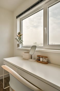 a white desk in front of a large window with a view of the city from it's top floor