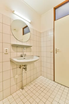 a bathroom with a sink and mirror on the wall next to an open door that leads to a small window