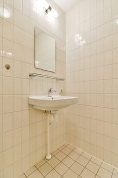 a bathroom with a sink and mirror on the wall next to it is a white tiled floor that looks very clean