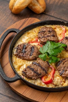 Meatballs with alinazik sauce. Traditional turkish meatballs on eggplant puree in cast iron skillet