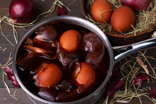 Coloring chicken eggs for Easter with onion peel. Easter, Sunday. Healthy food. Dark key, rustic. Selective focus.