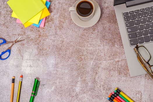 Office desk with laptop, and other work tools with coffee cup. Top view with copy space for entering text.