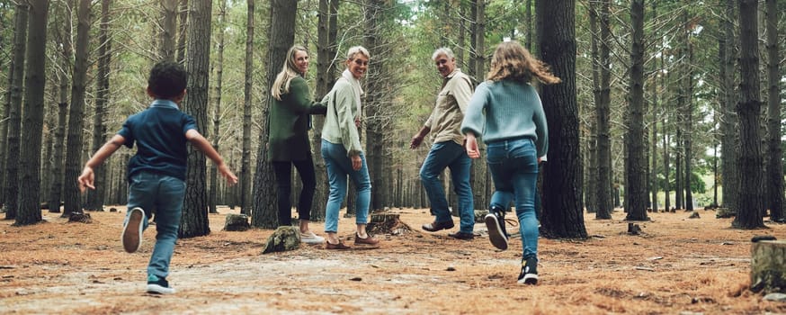 Forest, big family and adventure with children, parents and grandparents walking in nature for outdoor hiking, fun and trees on wellness vacation. Running kids, travel and happy man and women in wood.