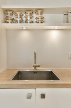 a kitchen with white cabinets and wood counter tops on the wall above it is a stainless sink that has been installed