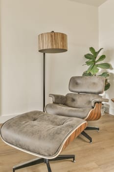 an empty living room with a chair, lamp and plant in the corner on the left side of the room