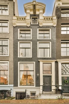 a very old house in the middle of an urban area, with many windows and bales on each side