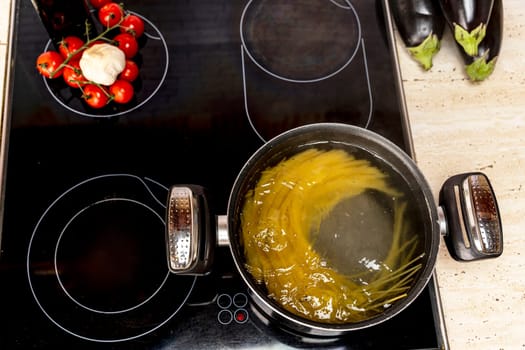 Spaghetti is cooked in a saucepan. Cooking delicious spaghetti in boiling water. pasta in a saucepan on the stove. top view