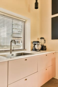 a kitchen with white cupboards and window blinds in the window sies, which are closed to let natural light into the room