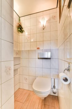 a bathroom with tiled walls and wood flooring on the wall, along with a white toilet in the corner