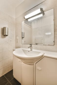 a bathroom with a sink, mirror and toilet paper dispensed on the wall in front of it