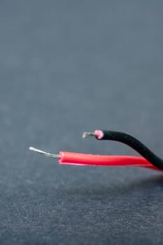 Bared red wire on a black background close up