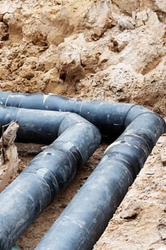 Black water pipe in the ground close up