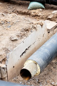 Black water pipe in the ground close up