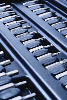 Black plastic box with bits for screwdriver close up, background