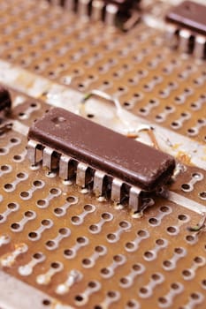 Old dirty yellow circuit board with transistors close up